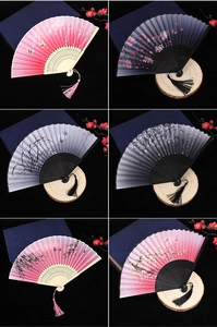 Close-up of silk folding fans featuring cherry blossoms, bamboo, and tassels