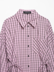 Détail de chemise à carreaux roses avec cordon à la taille et boutonnage classique