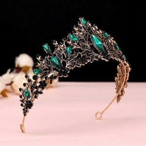Detail of a vintage golden bridal crown with emerald crystals and leaf motifs