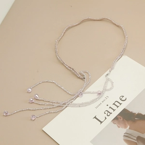 Detailed shot of lavender beaded headband with crystal tassels on a minimalist magazine