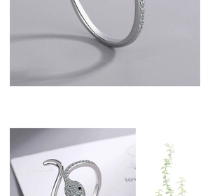 Macro shot of silver snake head ring with sparkling crystals and detailed texture