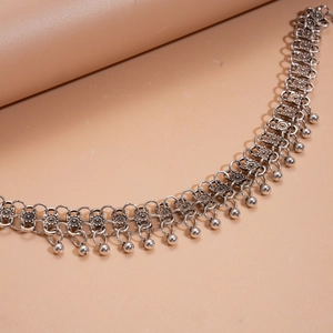 Detail of vintage silver bohemian waist chain with intricate metal cubes and ball pendants