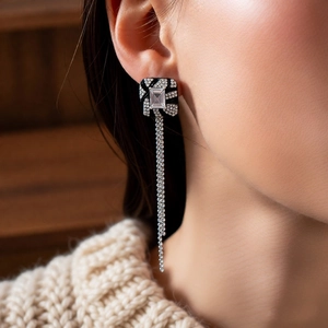 Close-up of vintage square crystal earrings with elegant long silver tassel chains