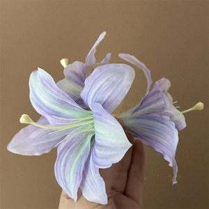 Detailed close-up of a realistic purple and green lily hair clip with soft petals