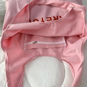 Pink canvas tote bag interior view featuring a zipper pocket and an open compartment