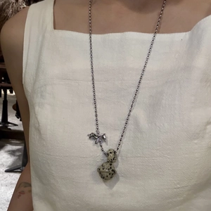 Detailed view of silver pony pendant with spotted stone beads on a classic bead chain