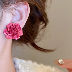 Close-up of rose red resin flower stud earrings worn by a model for a stylish look