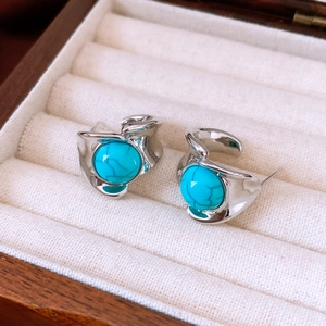 Vue détaillée de boucles d'oreilles turquoise vintage dans un cadre argenté