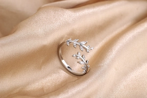Macro shot of silver olive leaf open ring featuring white cubic zirconia accents