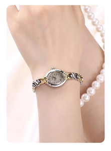 Détail de la petite montre vintage GEDI avec bracelet bicolore et cadran ovale au poignet