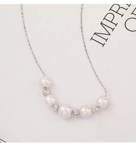 Detail of freshwater pearl necklace with silver beads on a minimalist display card