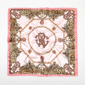 Detailed view of pink satin square scarf featuring leopard print and gold chain patterns