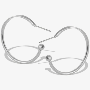 Detail of silver 304 stainless steel hoop earrings with sphere ends and polished finish