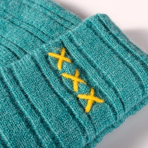 Winter teal knit beanie with decorative yellow cross stitching and ribbed wool texture