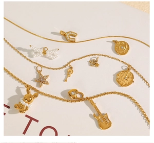 Detailed close-up of 18K gold plated charms with rhinestones and pearls on necklaces