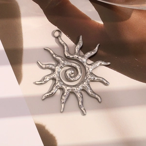 Detailed view of a silver sun pendant with a spiral center and hammered metal finish