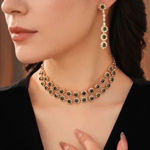 Vintage court style jewelry set with emerald green stones and gold tassel necklace