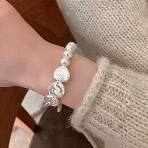 French retro bracelet featuring irregular heart pearls and T-bar clasp on female model