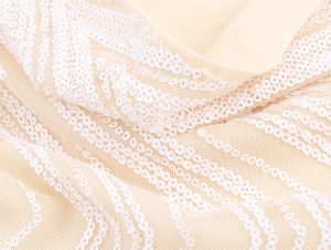 Detail of elegant champagne sequin mesh fabric with wavy pattern for evening dress