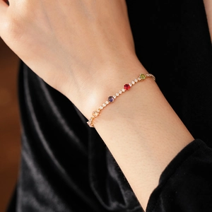Macro view of vintage gold tennis bracelet with colorful gemstones and white zircon crystals