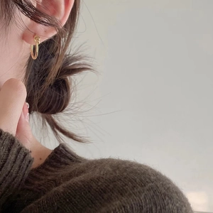 Minimalist S925 sterling silver knotted hoop earrings in gold finish worn by a model