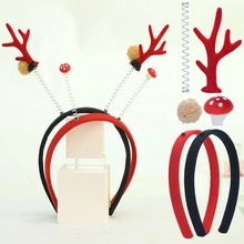 Detail showing DIY reindeer antler headband kit with red mushrooms and fuzzy pom poms