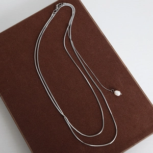 French vintage double layer silver snake chain necklace with pearl pendant on brown display