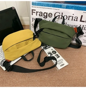 Detail of yellow and olive green nylon crossbody bags with adjustable straps on a rug
