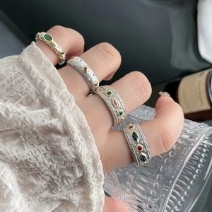 Vintage palace style rings with colorful gems and antique lace texture on hand