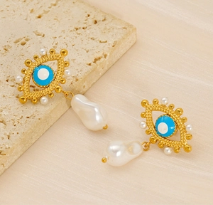 Detailed shot of evil eye earrings with blue enamel and natural baroque pearls