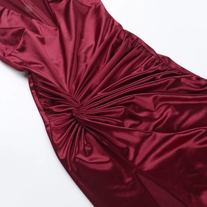 Détail de la robe en satin bordeaux montrant le nœud central et la texture plissée du tissu