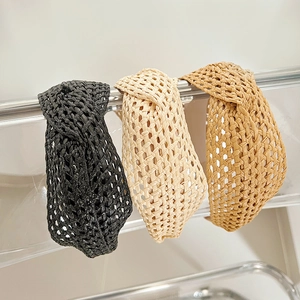 Trois serre-têtes tressés en noir beige et kaki sur support en acrylique transparent