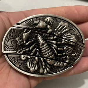 Macro shot of antique silver scorpion relief on a metallic belt buckle accessory