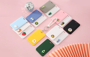 Detail view of colorful cartoon card holders with 3D resin charms and woven lanyards