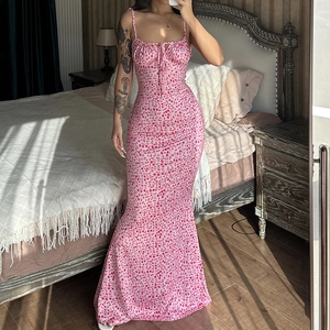 Pink floral sundress with ruched chest and tie-up detail in a sunny bedroom setting