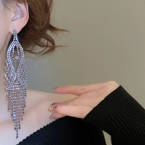 Macro detail of long tassel earrings with purple crystals and multi-layered silver chains