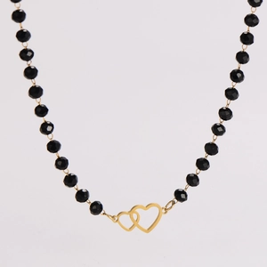 Detail of black faceted glass beaded necklace with interlocking gold heart pendants