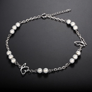 Titanium steel butterfly necklace with pearls on a dark textured background