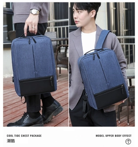 Detail of blue Oxford fabric backpack with USB port and leather base, shown with model