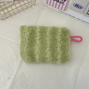 Detail of green striped plush cosmetic bag with pink braided zipper pull strap