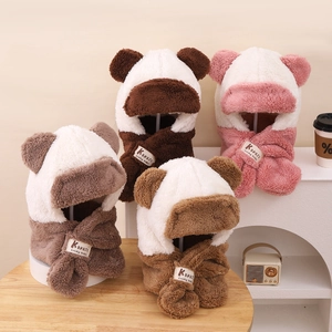 Détail de quatre bonnets à rabats en peluche pour enfants avec oreilles d'ours et écharpe