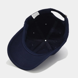 Detail view of cotton baseball cap interior lining with adjustable strap and care label