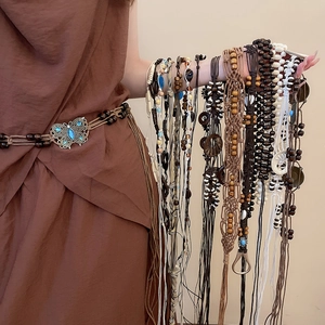 Detail of bohemian hand-woven waist chain with wooden beads and butterfly metal buckle