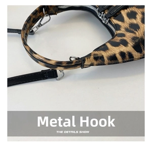Detailed close-up of polished silver metal hooks on a leopard print patent leather handbag