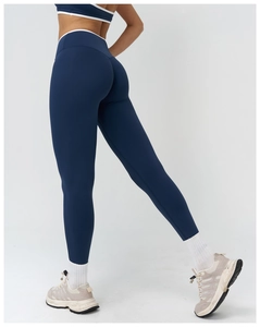 Dettaglio dei pantaloni yoga a vita alta con piping bianco e fascia elastica alta