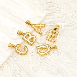 Golden titanium steel alphabet necklaces with A-E initial pendants on white marble