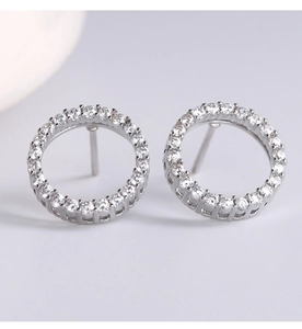 Macro view of silver round stud earrings with micro-set zircon stones in a minimalist style
