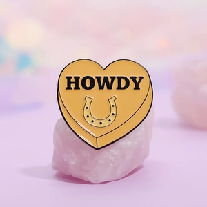 Enamel heart brooch with HOWDY text and horseshoe motif on pink crystal stones
