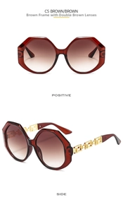 Detail view of large brown vintage sunglasses with golden Greek fret metal temples
