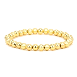 Macro detail of polished 18K gold plated solid round beads on an elastic bracelet